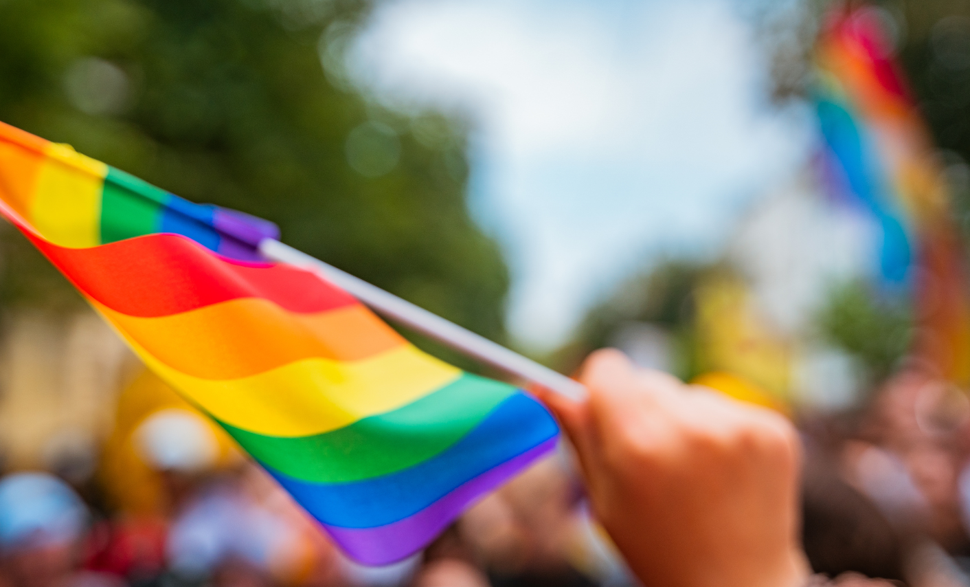 Pride-Flagge wird in einer Hand geschwungen
